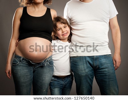 little girl with her father and pregnant mother