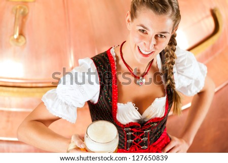 Woman in Bavarian Tracht, a female brewer, with beer stein in brewery