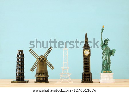 concept photo of some of the world famous landmark for travel , small statues over wooden table
