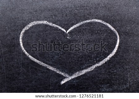 White chalk hand drawing in heart shape on black board background