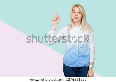  beautiful blond business woman pointing at copy space