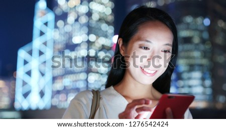 Woman work on smart phone in city at night