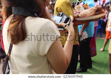 The girl is taking pictures of people at the wedding