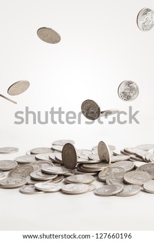 A group of pure silver coins are falling down into a pile.