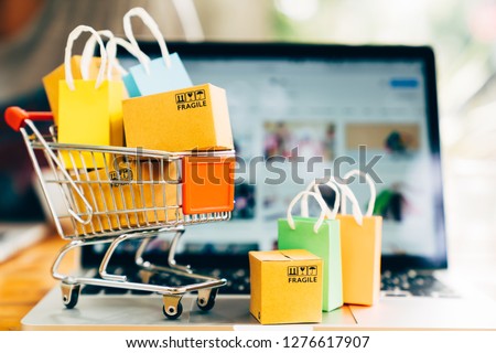Product package boxes and shopping bag in cart with laptop computer which web store shop on screen for online shopping and delivery concept Royalty-Free Stock Photo #1276617907