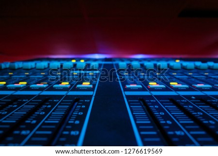 Wide angle closeup of Pro Audio Digital Mixing Console. White Faders and black control Console