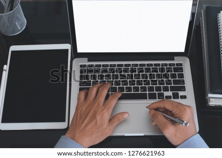 Business and technology concept. Mockup image of business man working on blank screen laptop computer with digital tablet on desk in modern office, top view