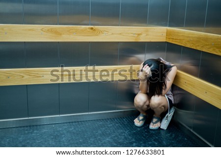 woman stuck in the elevator, girl very sad
