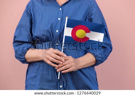 Colorado state flag. Close up of hands holding Colorado flag.