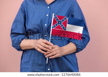 Mississippi state flag. Close up of hands holding Mississippi flag.