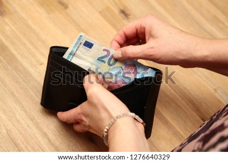 Woman taking out euro bank notes of her wallet