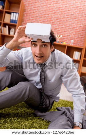 Young employee with virtual glasses during break in the office 