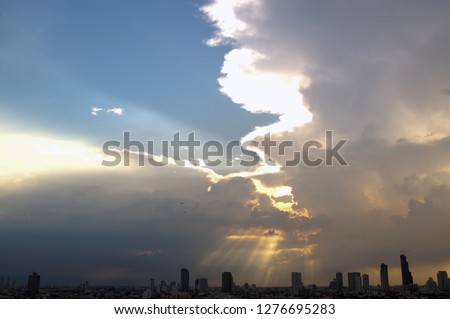 The skyscrapers in downtown Bangkok cityscapes, the capital of Thailand in southeast Asia, with golden sun rays through white cloud at sunset in summer in horizontal view.