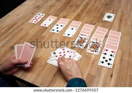 Woman playing solitaire at home Royalty-Free Stock Photo #1276699507