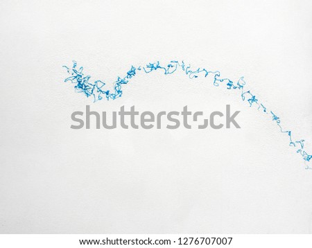 Minimal close up shot over a big blue sticky product stain in a white wall, representing a jump or a wave, in an artistic abstract way.