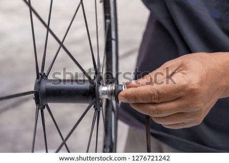 Man hand repairing and lubricate the bicycle wheel bearing. Maintenance concept.
