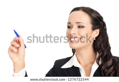 Happy smiling cheerful beautiful businesswoman writing or drawing something on screen or transparent glass, by blue marker, isolated against white background