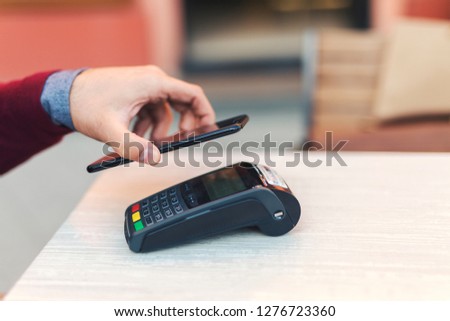 Closeup of a wireless payment with mobile phone with NFC technology.
