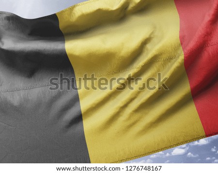 Belgium national flag silk fabric on blue sky textile cloth fabric waving