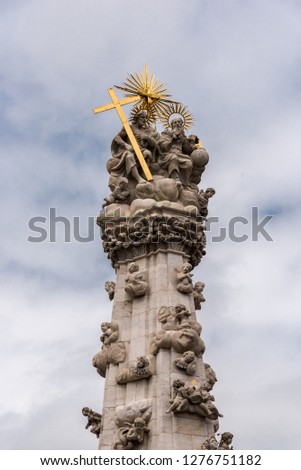 monument with statue and cross with sky and clouds background