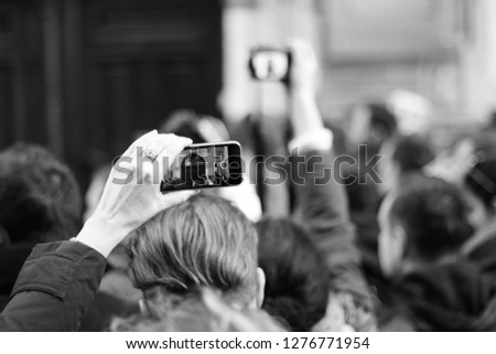 People are waiting for a star. The crowd shoots a star on the phone. Paparazzi everywhere. Journalists are waiting for a star near the hotel. Black and white