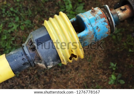 A universal mechanical joint which is used to couple a farm tractor to a lawn mower. 