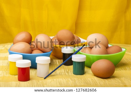 watercolors brush and easter eggs on yellow background