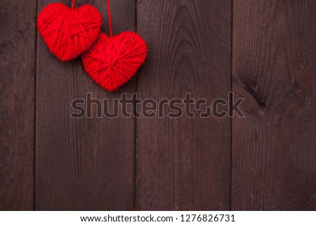 Two heart made of red wool yarn on wood background.Valentine's day concept