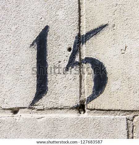 house number fifteen , painted on aerated concrete.