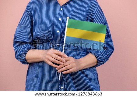 Gabon flag. Close up picture of hands holding national flag of Gabon.