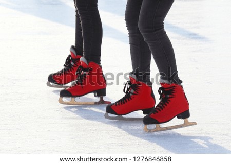 feet in red skates on an ice rink