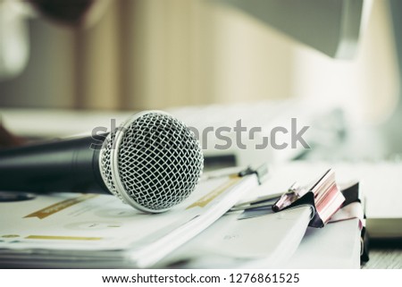 Teacher / speaker hold Microphone with paper document at seminar for speaking or lecture at classroom university with computer desktop on desk. Speech Conference at School Concept. Vintage Tone