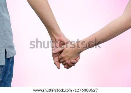 close up on couple human hand touching and holding together isolated on blur pink gradient background for relationship goal , married anniversary and valentine's day and human rights concept