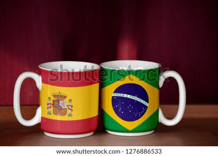 Brazil and Spain flag on two cups with blurry background