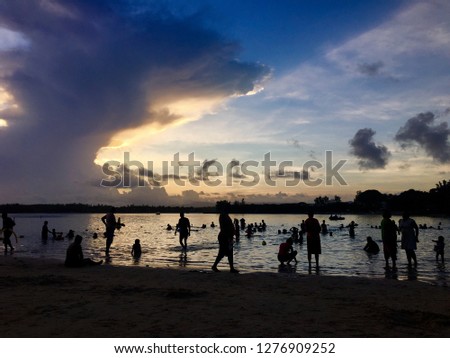 People silhouettes on the beach at sunset