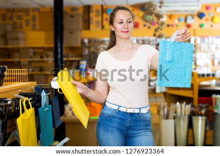 Positive woman demonstrates multi colored and other gift bags