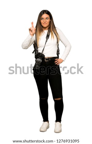Full body of Young photographer woman with fingers crossing and wishing the best