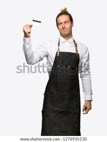 Barber man in an apron taking a credit card without money on isolated background