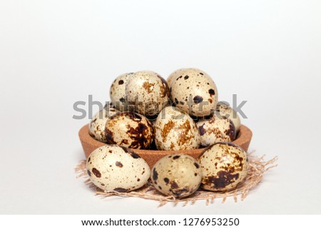 Closeup Easter small fresh textural quail eggs in round wooden bowl with textile isolated on white background. Concept traditional treat Orthodox Christian spring church holiday. Free space, copyspace