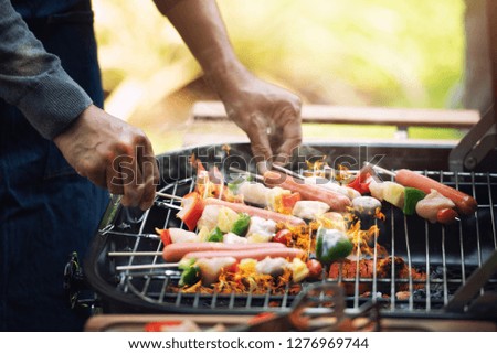 A Man Grills Barbecue on Charcoal Stove , He Cooking for BBQ Party with Friends at Home