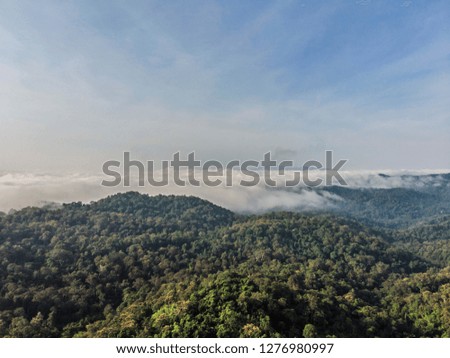 Landscape of Morning Mist with Mountain Layer at  north of Thailand. Aerial View. Flying over the high mountains in beautiful clouds . Aerial camera shot.