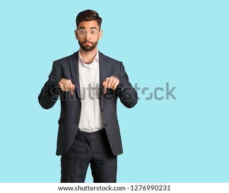 Young handsome business man pointing down