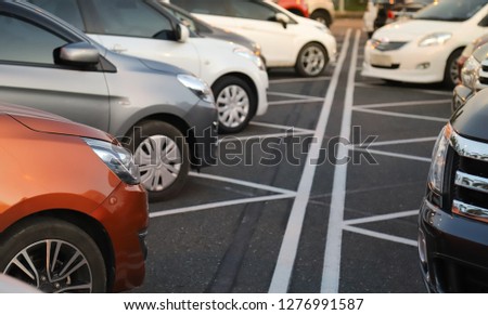 Closeup of front side of cars parking in parking area in opposite direction with natural background in twilight evening of sunny day. Royalty-Free Stock Photo #1276991587