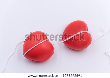 Two red heart ball put on white background tied to gether with white rope,for tell good health or tell love in valentine day.