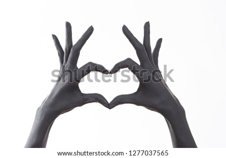 Black painted woman's hand doing heart symbol. Symbol of love, declaration of love. Woman Doing heart shape with hand and fingers. Feelings. unrequited love. 