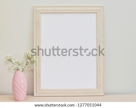 Empty decorative frame mockup, pink vase with flowers, styled feminine photography.