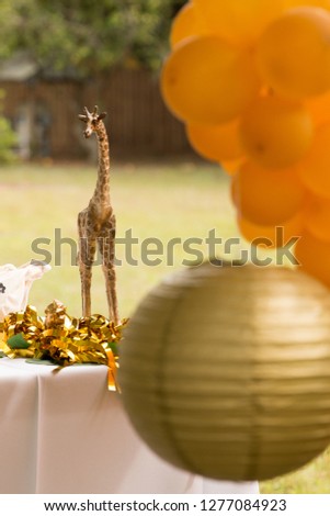 Safari themed Birthday party giraffe center piece gold paper ball and orange  balloons 