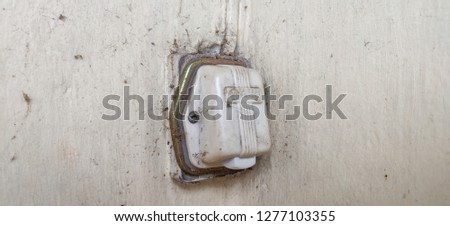 Old switch. Dirty doorbell on the old wall.