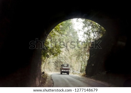 Car drives through the Highway Urban Tunnel. View from badly lit tunnel from a fast moving car on a sunny day. Motion Blur Background.