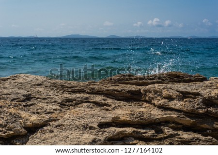 Photo of Waves breaking on a stony beach in Murter, Croatia, Dalmatia